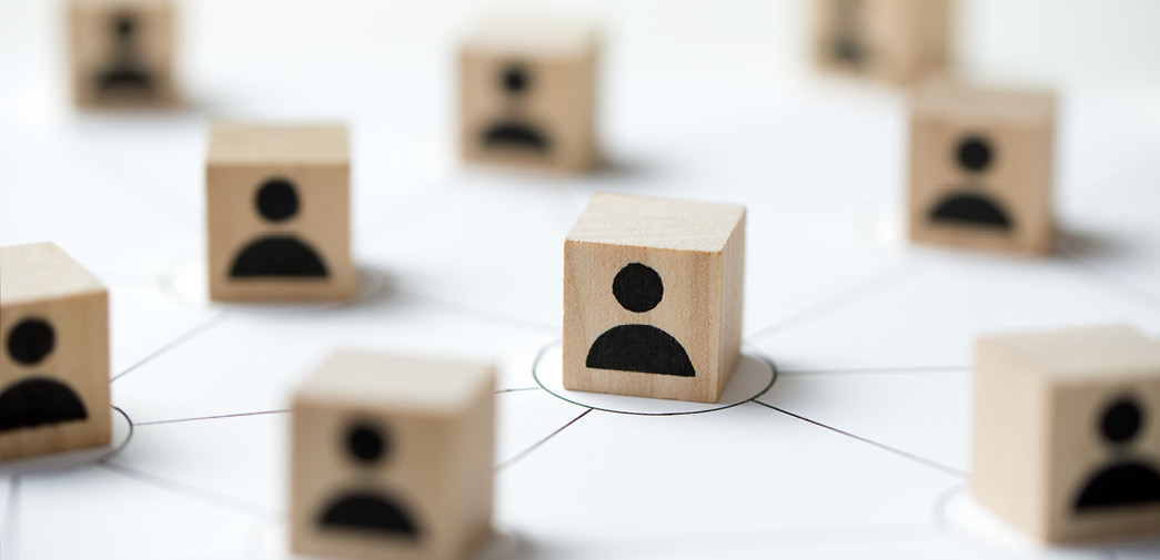 Four wood blocks, each containing silhouettes of a person, placed on a map