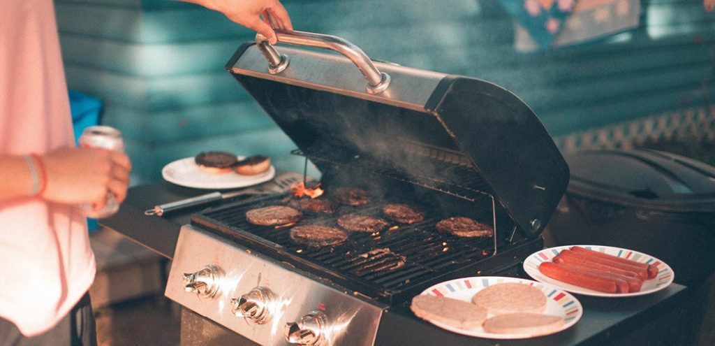 An agent grills at a summer cookout