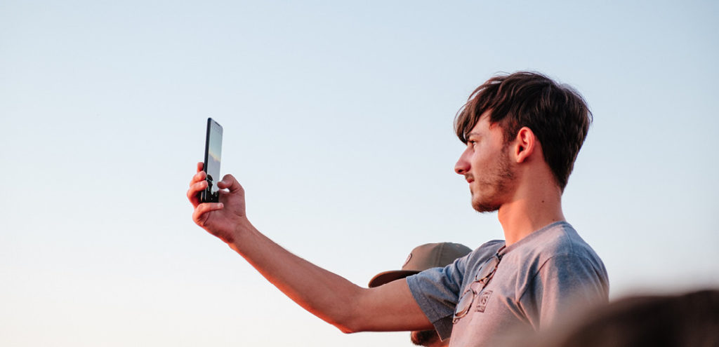 A man takes a photo with his smartphone's camera