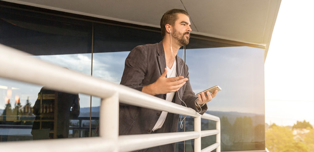 An agent leans over a balcony and holds a conversation on a cell phone