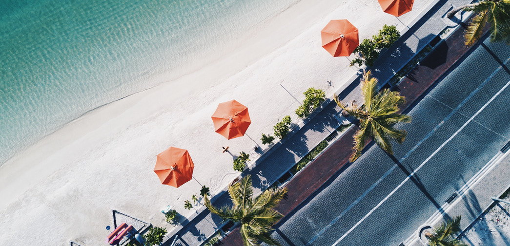 An overhead shot of a beach and two umbrellas