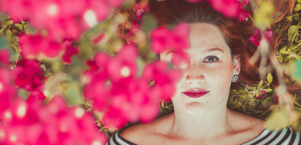 A woman's face is partially obscured by flowers