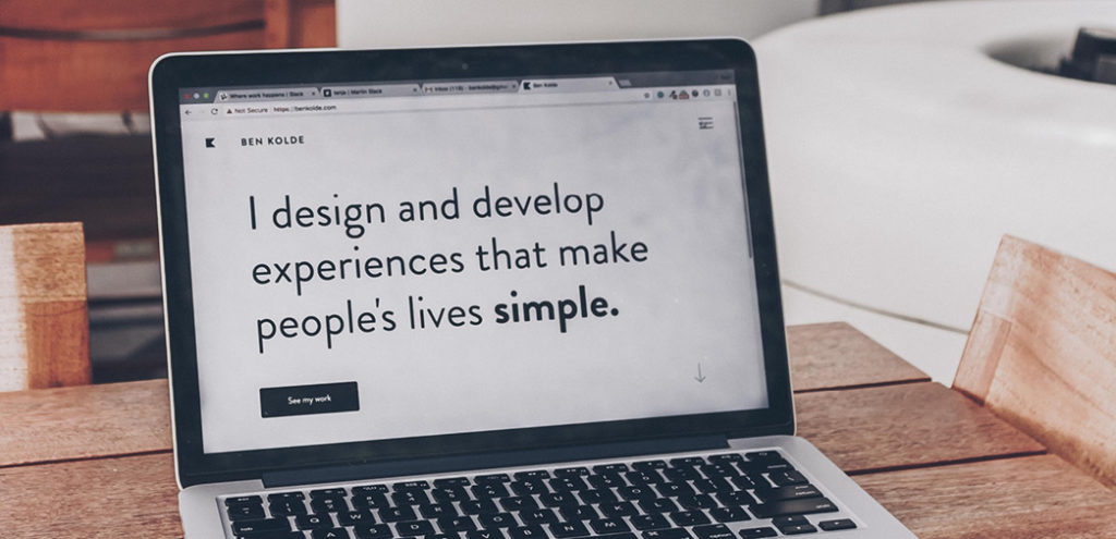 Text on a laptop screen; It reads "I design and develop experiences that make people's lives simple."