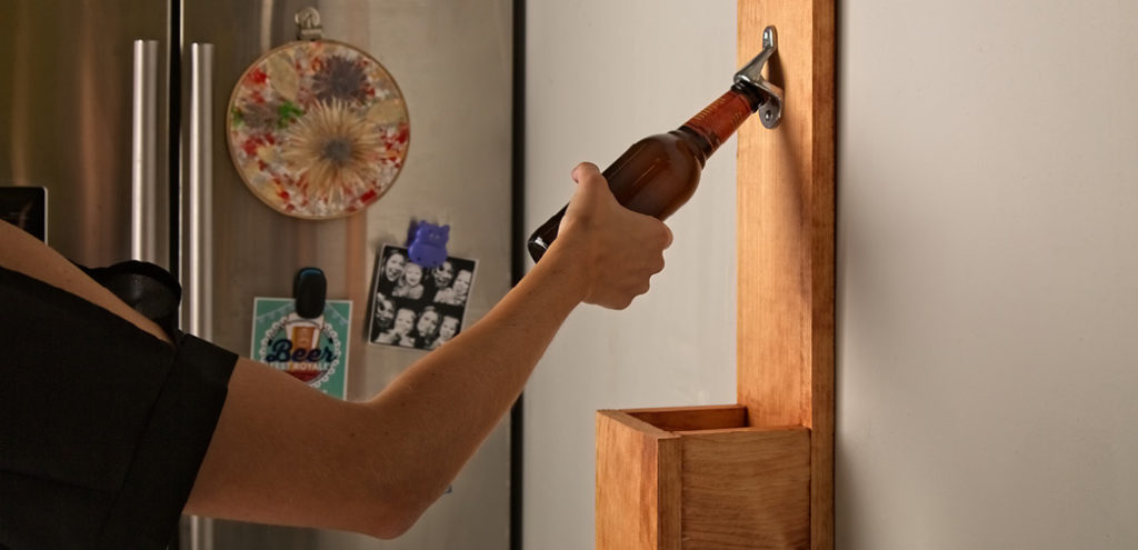 A wood-framed bottle opener hung on a wall