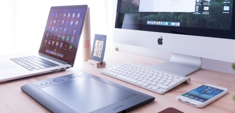 A workstation is set up with multiple tech devices