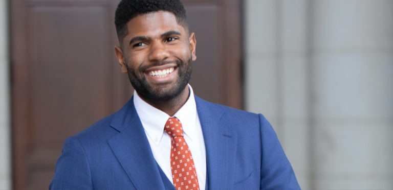 man in blue suit with orange tie
